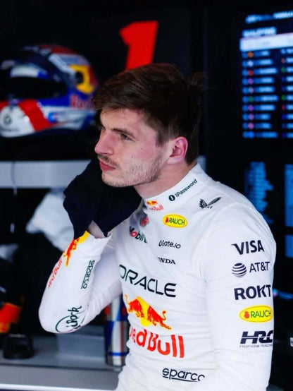 Person in a racing suit with various sponsor logos in a garage setting