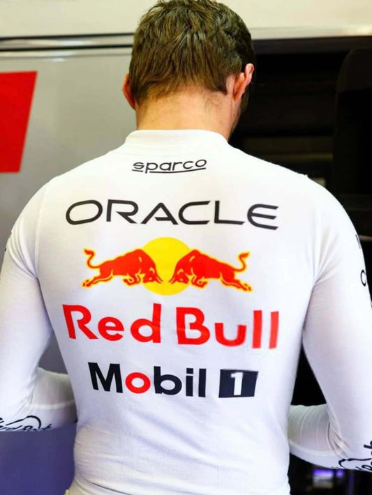 Person wearing a white racing suit with Red Bull and Oracle logos.