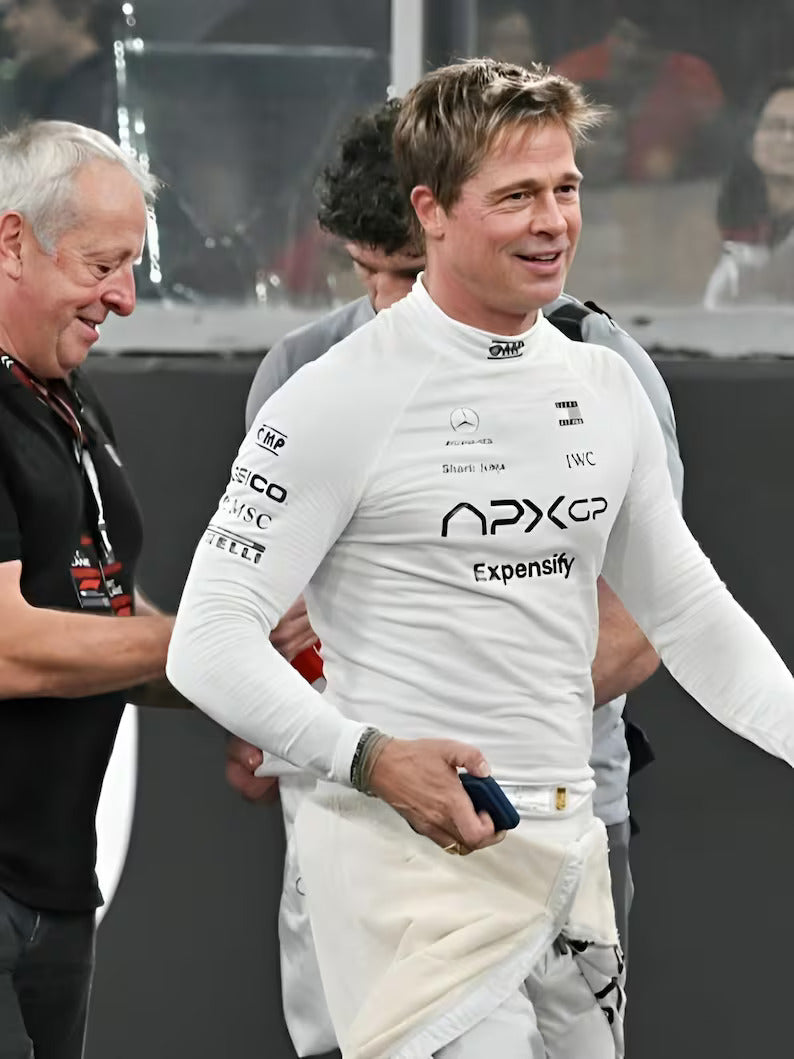 Person in a racing suit with visible branding, standing next to another person.