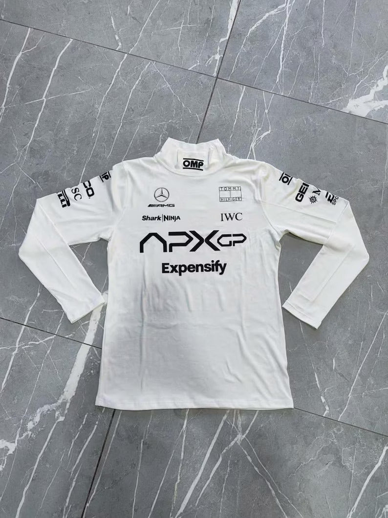 White long-sleeve shirt with various logos on a gray marble surface
