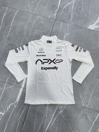 White long-sleeve shirt with various logos on a gray marble surface