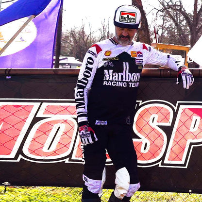 Person wearing a Marlboro Racing Team uniform standing in front of a branded backdrop