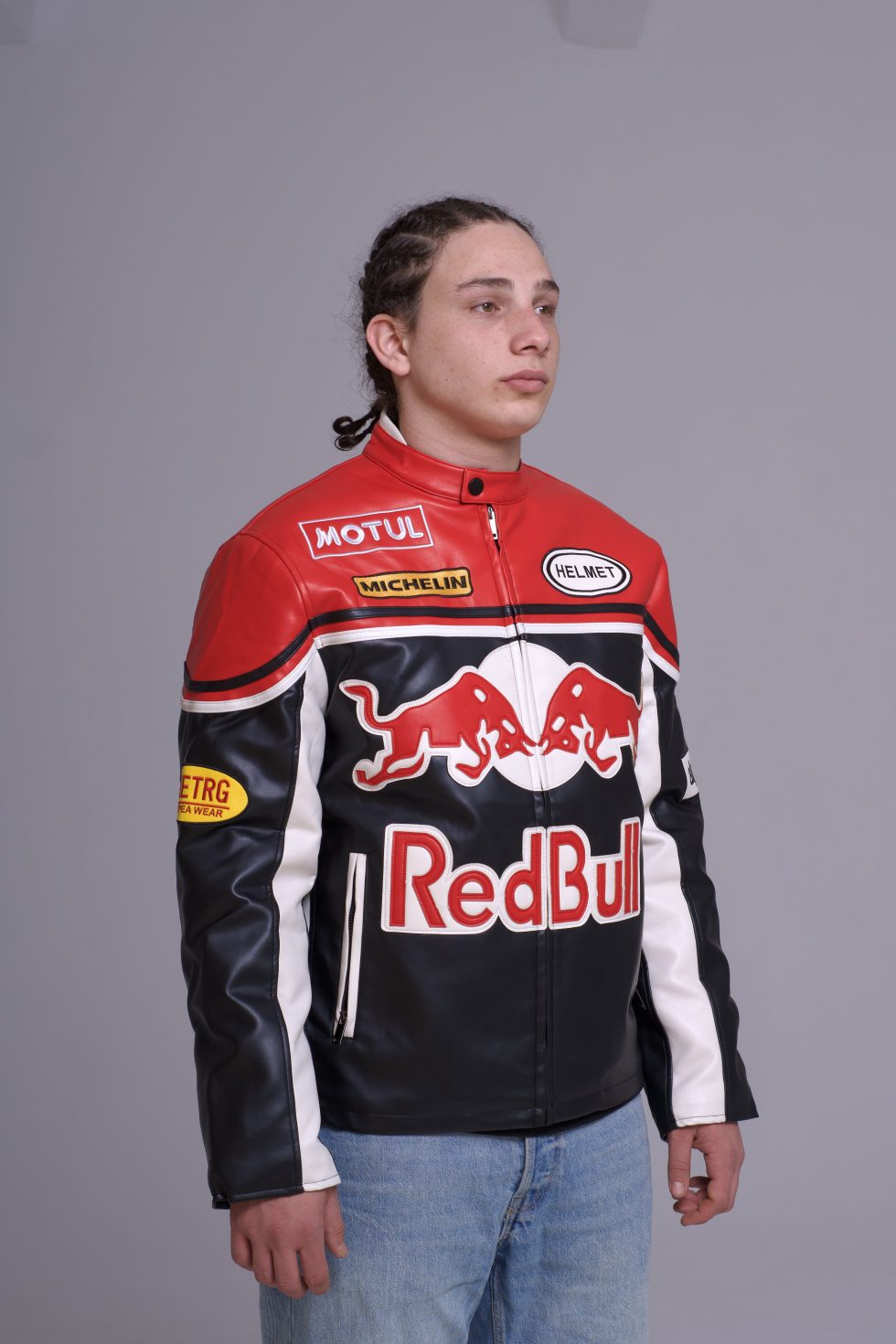 Person wearing a Red Bull branded jacket on a gray background