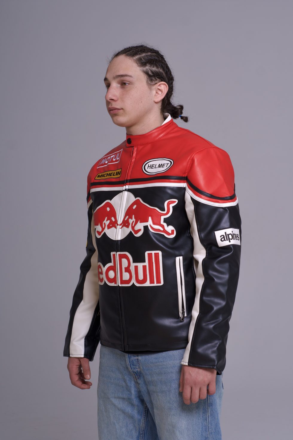 Person wearing a Red Bull branded leather jacket on a gray background