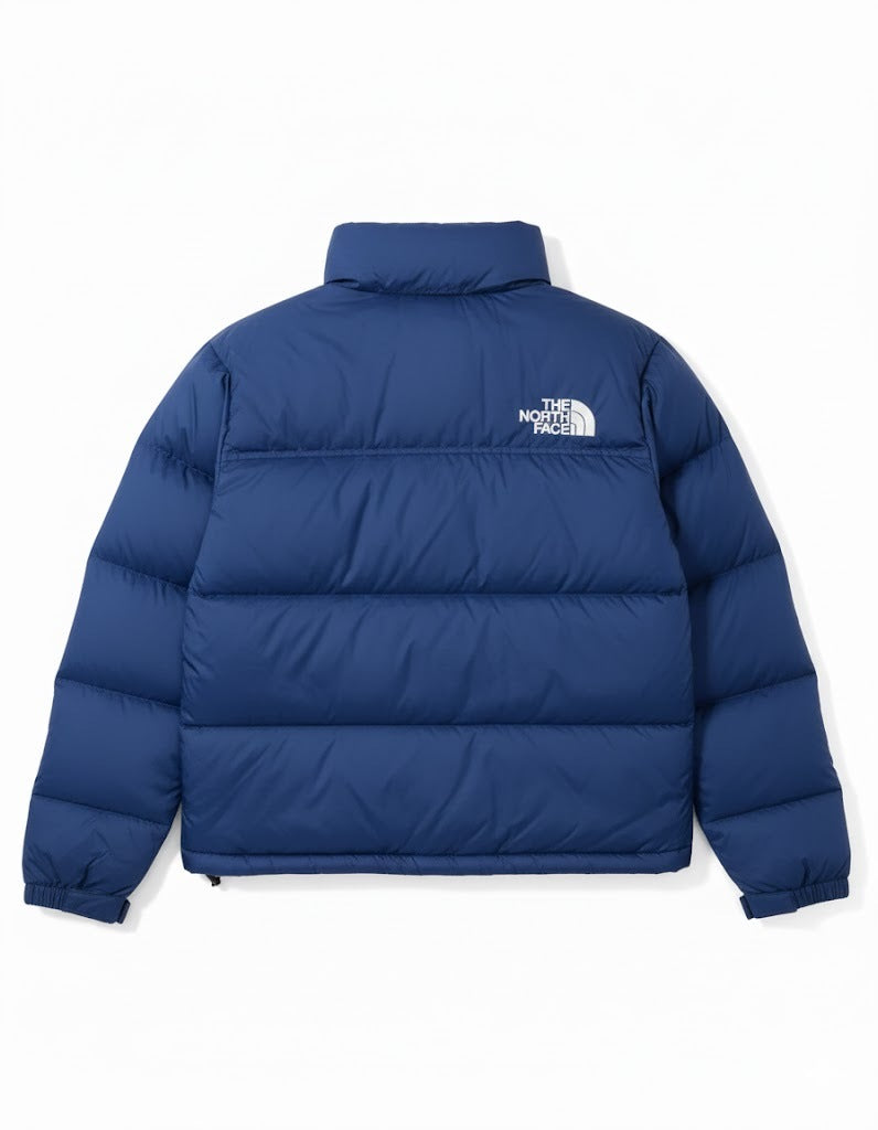 Blue puffer jacket with The North Face logo on a white background