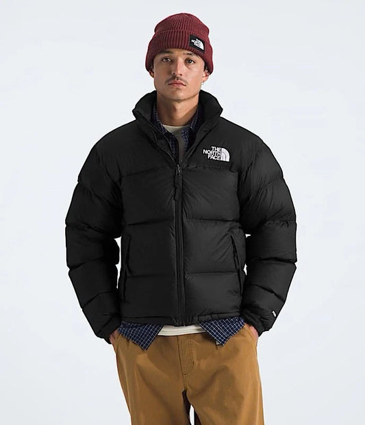 Person wearing a black puffer jacket with 'The North Face' logo on a white background