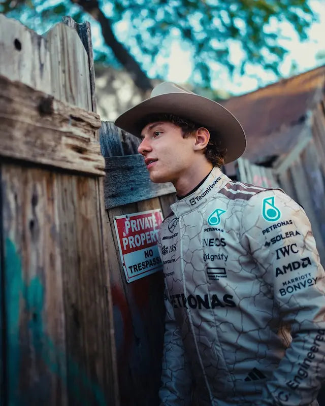 Person wearing a branded jacket leaning against a wooden fence with a 'Private Property' sign.