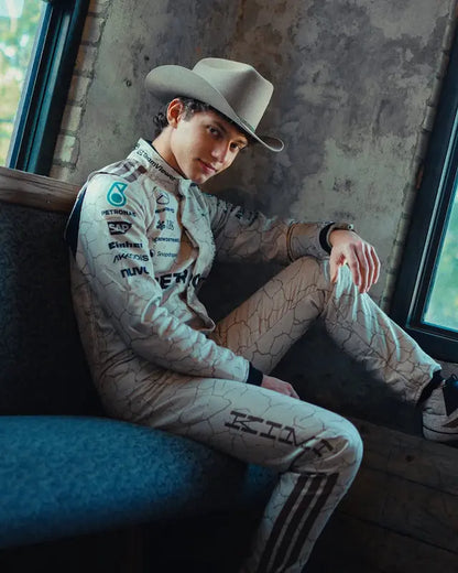 Person wearing a racing suit and cowboy hat sitting in a vehicle.