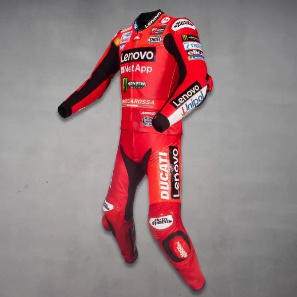 Red motorcycle racing suit with various brand logos on a gray background